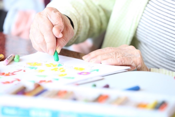 Elderly person doing activities like coloring